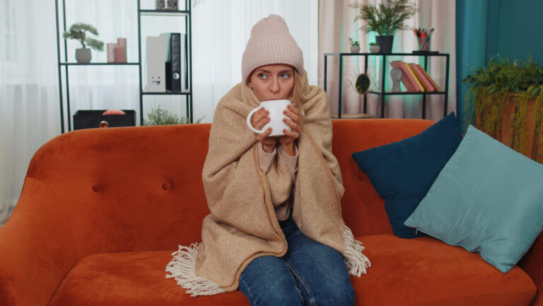 Girl drinking coffee wrapped in blanket